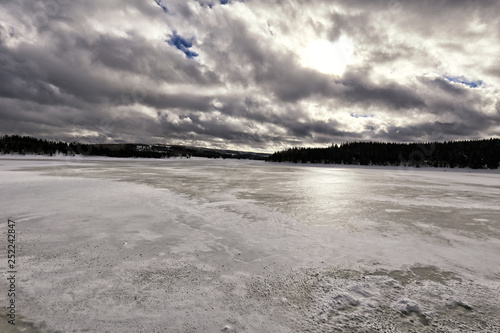 Large frozzen lake with forests around photo