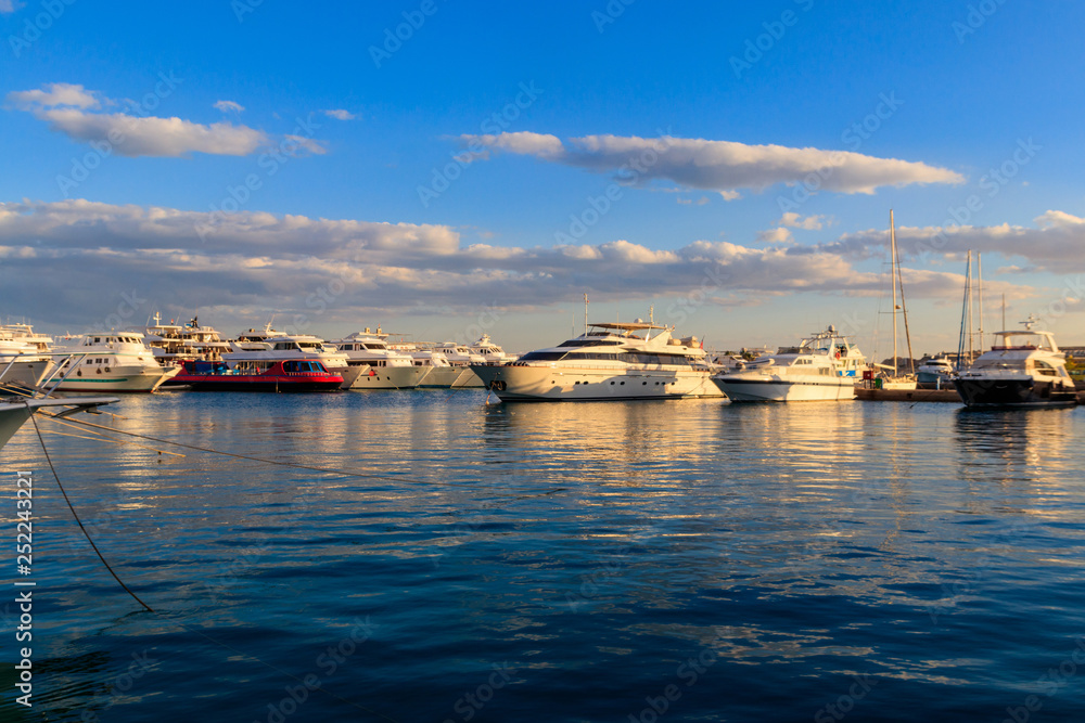 White yachts in the sea harbor of Hurghada, Egypt. Port with tourist boats on the Red Sea