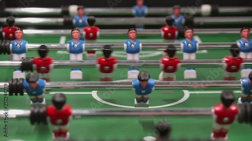Friends having fun together playing table football indoor. Office people enjoying table soccer game. Close up of table football kicker game.