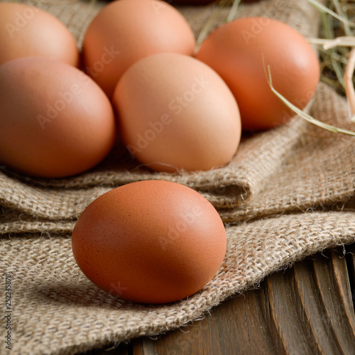 Fresh brown organic chicken eggs on wooden table and hemp burlap