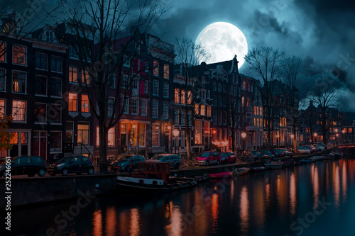 City scenic from Amsterdam in the Netherlands by night at full moon