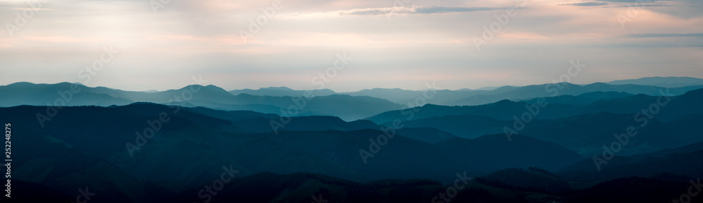 Background panorama with mountains in the fog. Dark sunset time Background panorama with mountains in the fog. Dark sunset time