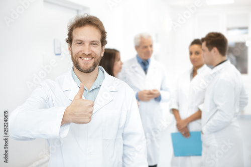 Happy professional doctor smiling showing thumbs up