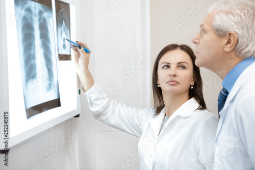 Two doctors discussing x-ray scans of their patient