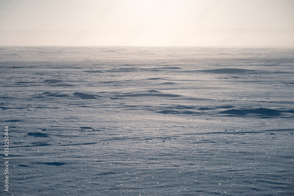 Winter landscape. The surface of the frozen sea. A little fog