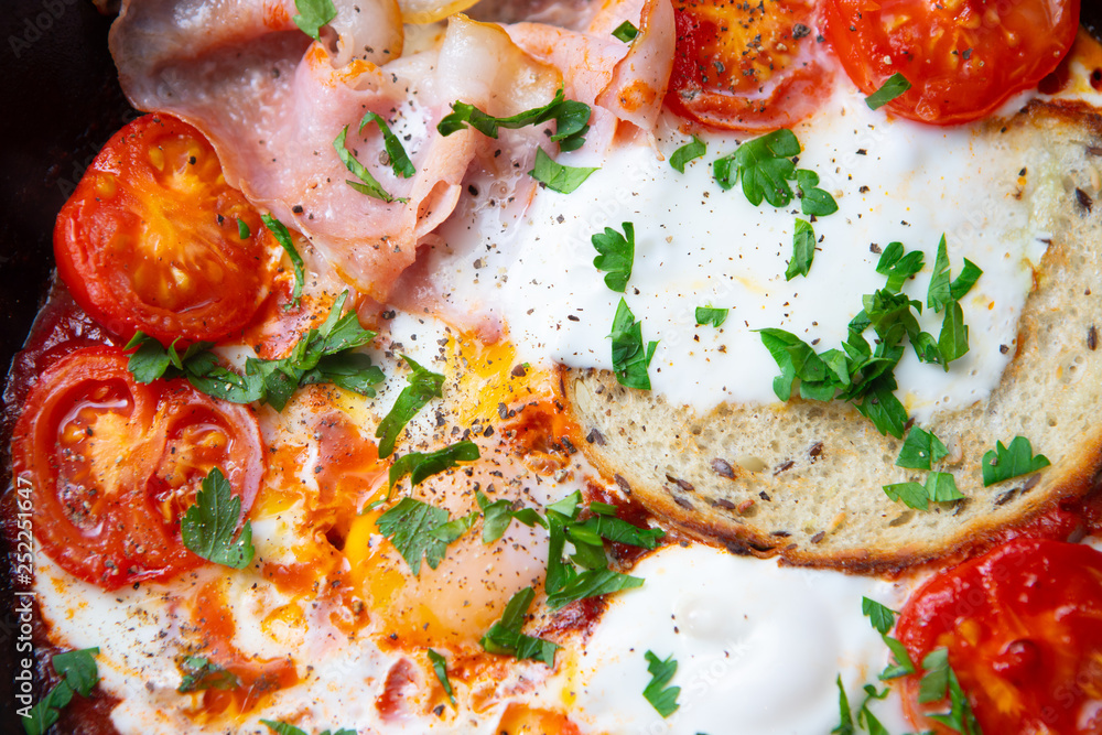 Fried eggs with bacon, toast and tomatoes in a pan Fried eggs with bacon, toast and tomatoes in a pan