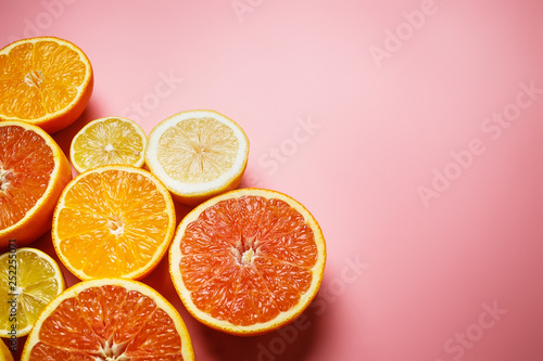 orange. lemon and grapefruit with fresh juice on the pink background 