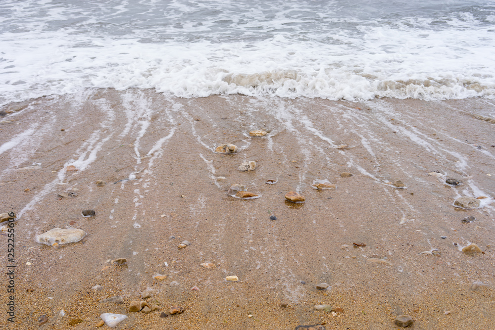 Stones at a sandy pebble beach with the sea withdrawing Stones at a sandy pebble beach with the sea withdrawing