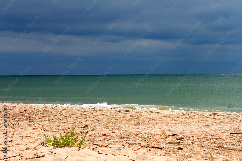 Sandy beach shore and cloudy stormy sky over the sea Sandy beach shore and cloudy stormy sky over the sea