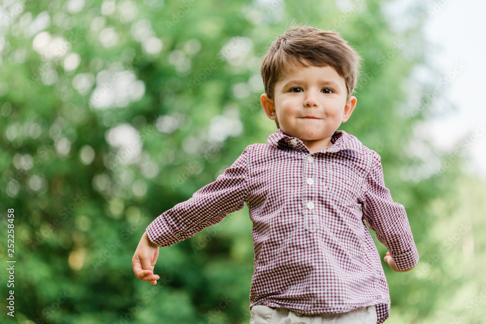 Cheerful cute little boy having fun in park. Happy childhood. Cheerful cute little boy having fun in park. Happy childhood.