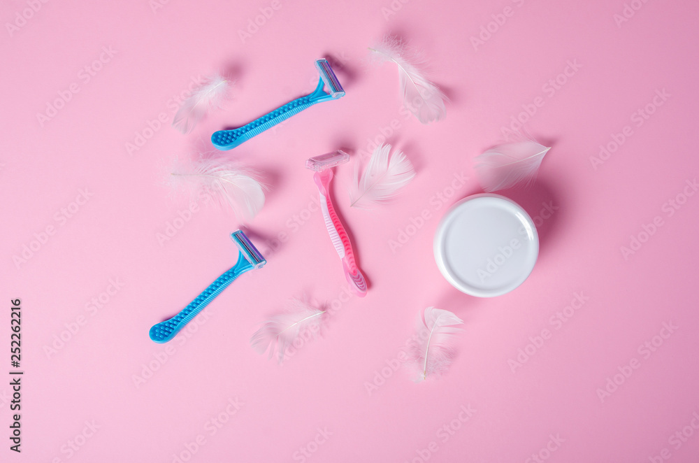 razor, white feather, jar cream soft beauty on pink background, top view razor, white feather, jar cream soft beauty on pink background, top view