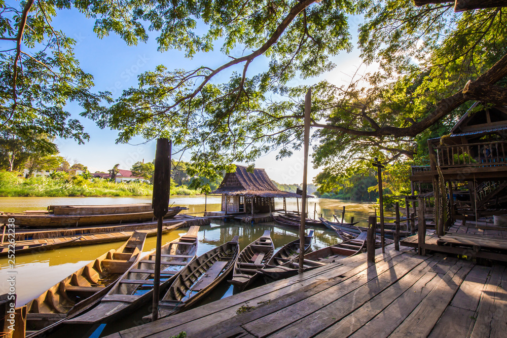 Obraz premium Wooden boat on pier of oriental house style in local river