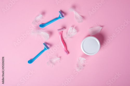 razor, white feather, jar cream soft beauty on pink background, top view © Kabardins photo