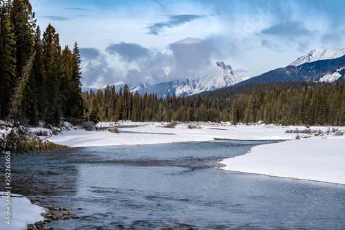 Peaceful winter scene along the Kootenay River in Kootenay National Park British Columbia. Pillows of snow along the riverbaks © MelissaMN