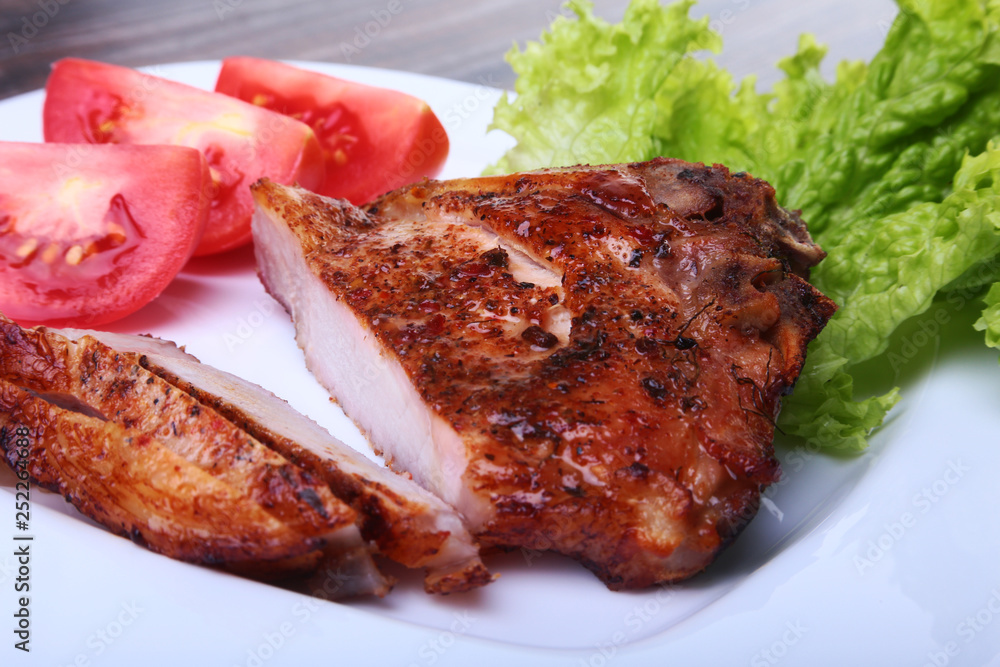 grilled pork chops with tomato, leaves lettuce and ketchup on plate. grilled pork chops with tomato, leaves lettuce and ketchup on plate.