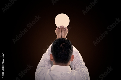Pastor prays to God consecration a bread photo