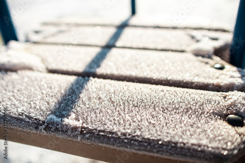 winter background: frozen snowflakes close-up on a sunny day on a tree swing,