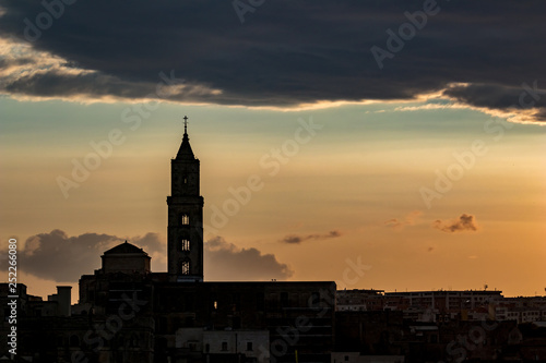 Amazing sky and church silhouette view of ancient town of Matera, the Sassi di Matera, Basilicata, Southern Italy, cloudy summer afternoon just before sunset