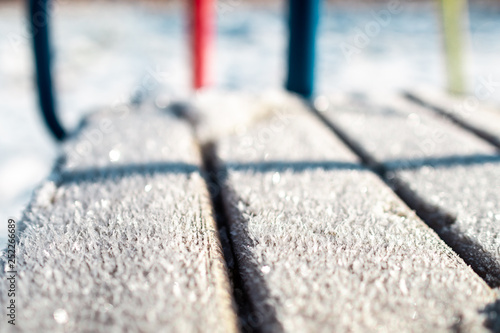 winter background: frozen snowflakes close-up on a sunny day on a tree swing,