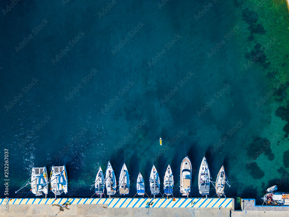 Aerial view of floating boat on transparent turquoise water at sunny day. Summer seascape from air. Top view from drone. Travel concept and idea Aerial view of floating boat on transparent turquoise water at sunny day. Summer seascape from air. Top view from drone. Travel concept and idea