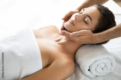 Young and beautiful woman during facial massage session