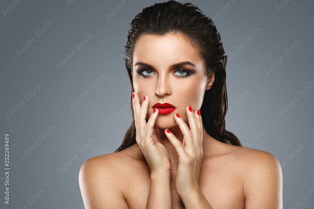 Portrait of beautiful young woman with a red lipstick and nail polish Portrait of beautiful young woman with a red lipstick and nail polish