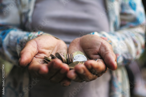 Old hand holding coin , Saving and growing business concept, selective and soft focus.