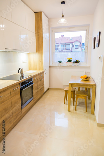 Fototapeta Naklejka Na Ścianę i Meble -  Aesthetic modern narrow kitchen with wooden furnitures