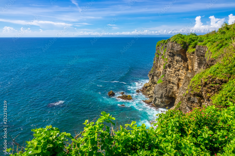 Indonesia. Rocky Coast of a Tropical Island and Sunny Day. Stock photo.