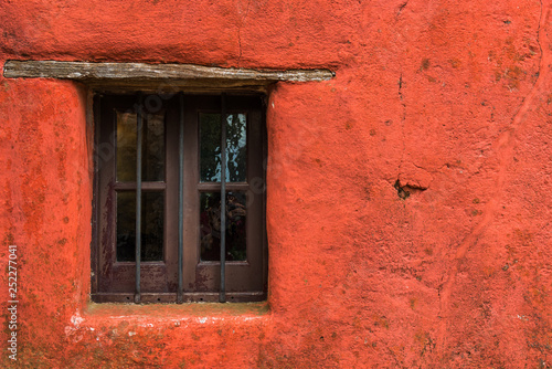 Colorful red vintage retro window and wall of an old house building
