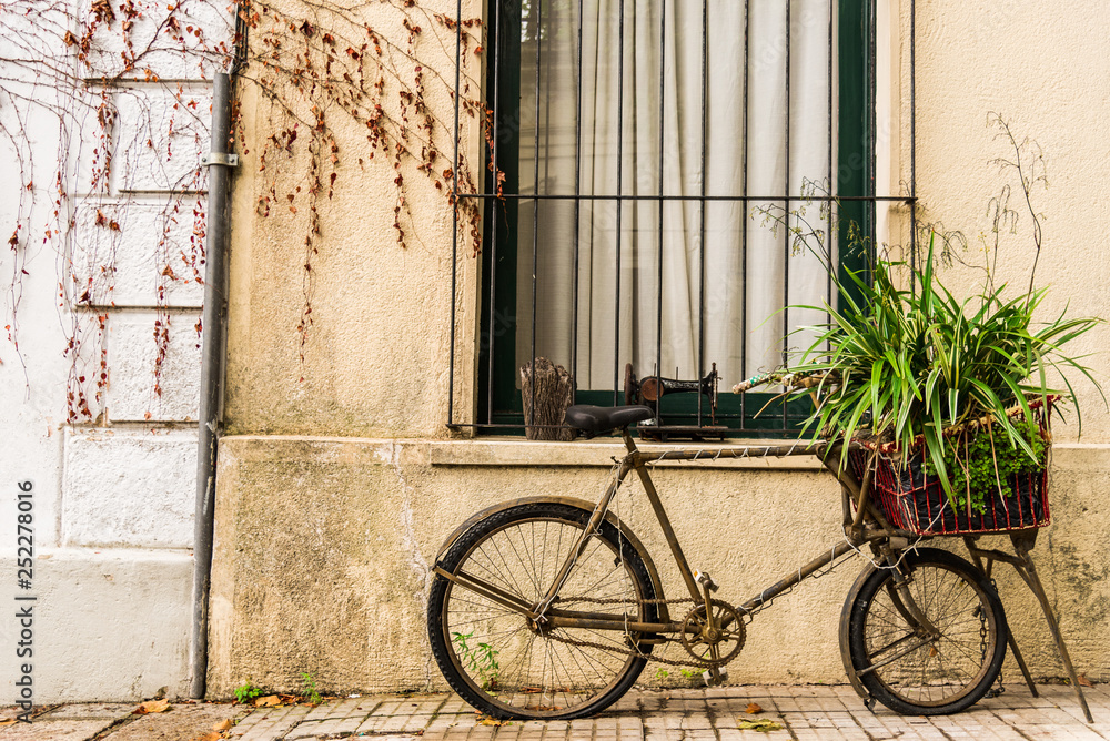 A retro vintage old bicycle against the wall of a colonial and colorful house. Concept of travel, adventure, and lifestyle