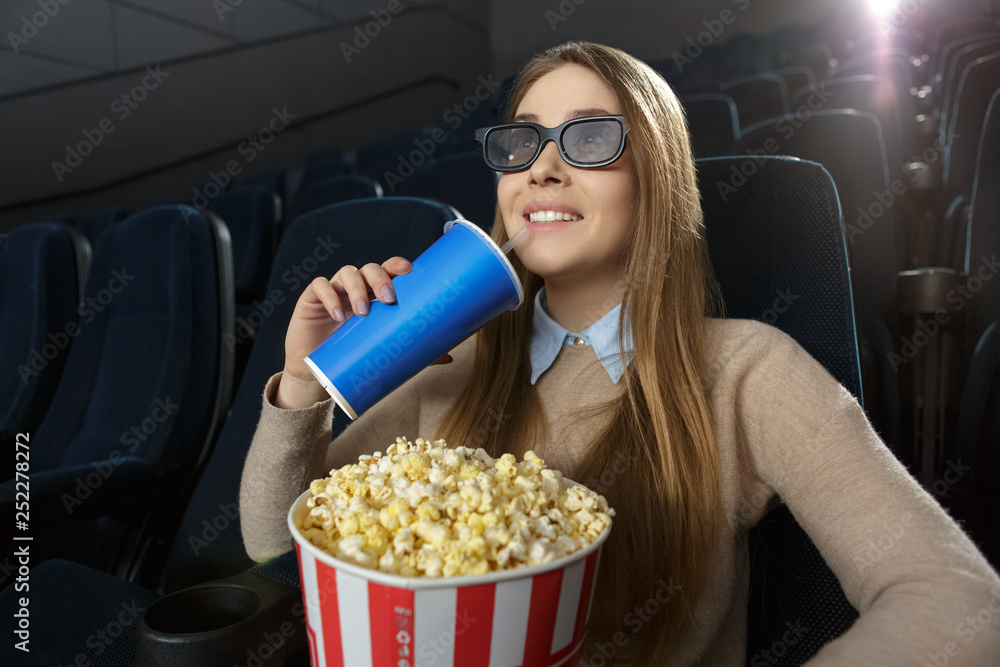 Young woman watching a 3D movie in an empty movie theatre Young woman watching a 3D movie in an empty movie theatre