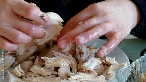 A woman takes off his boiled chicken meat, shred all boiled chicken, boiled chicken meat,
