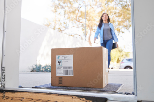 Woman Coming Back To Home Delivery In Cardboard Box Outside Front Door