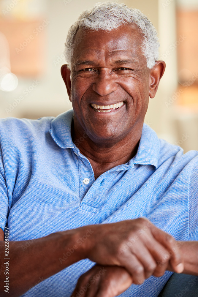 Portrait Of Smiling Senior Man Relaxing On Sofa At Home Portrait Of Smiling Senior Man Relaxing On Sofa At Home