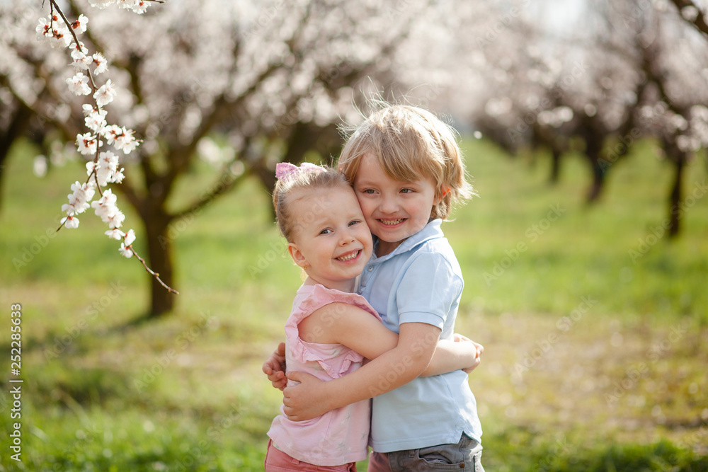 happy children on the street in the spring , flowering gardens happy children on the street in the spring , flowering gardens
