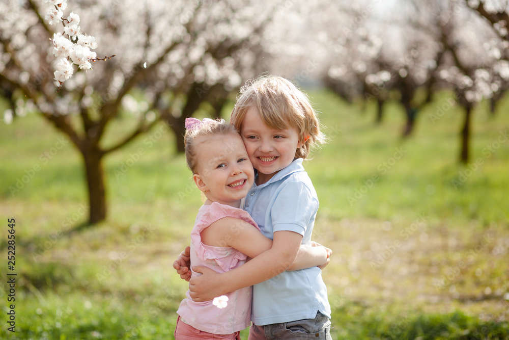 happy children on the street in the spring , flowering gardens happy children on the street in the spring , flowering gardens