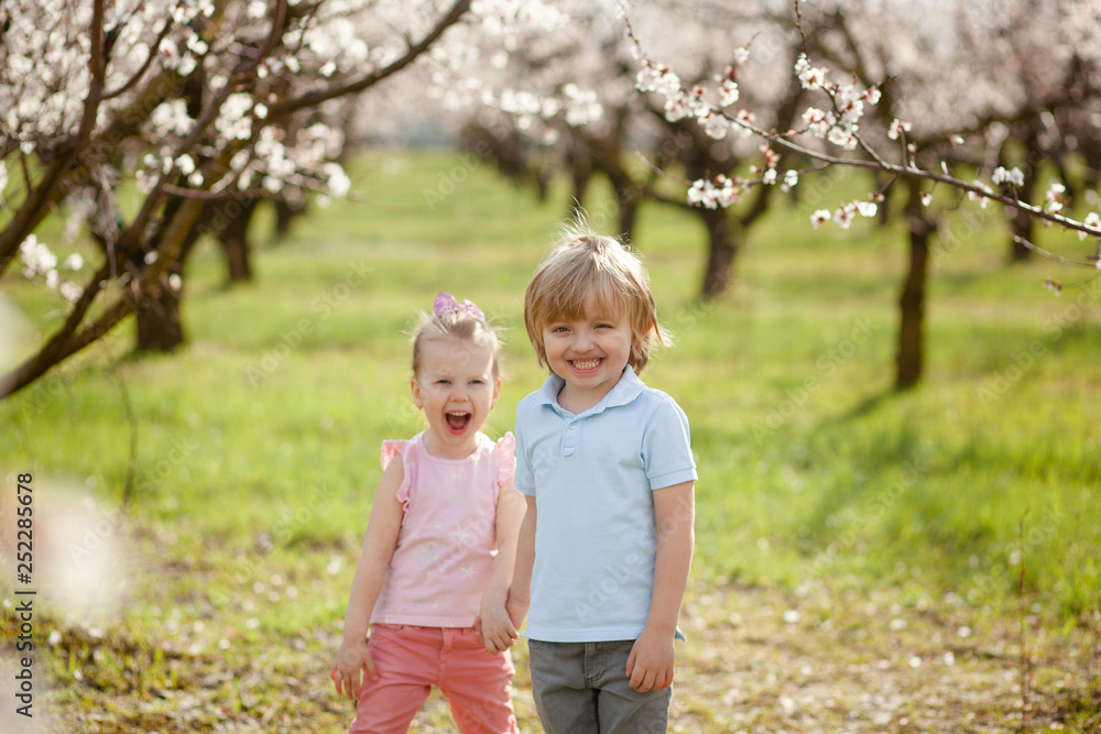 Fototapeta premium happy children on the street in the spring , flowering gardens