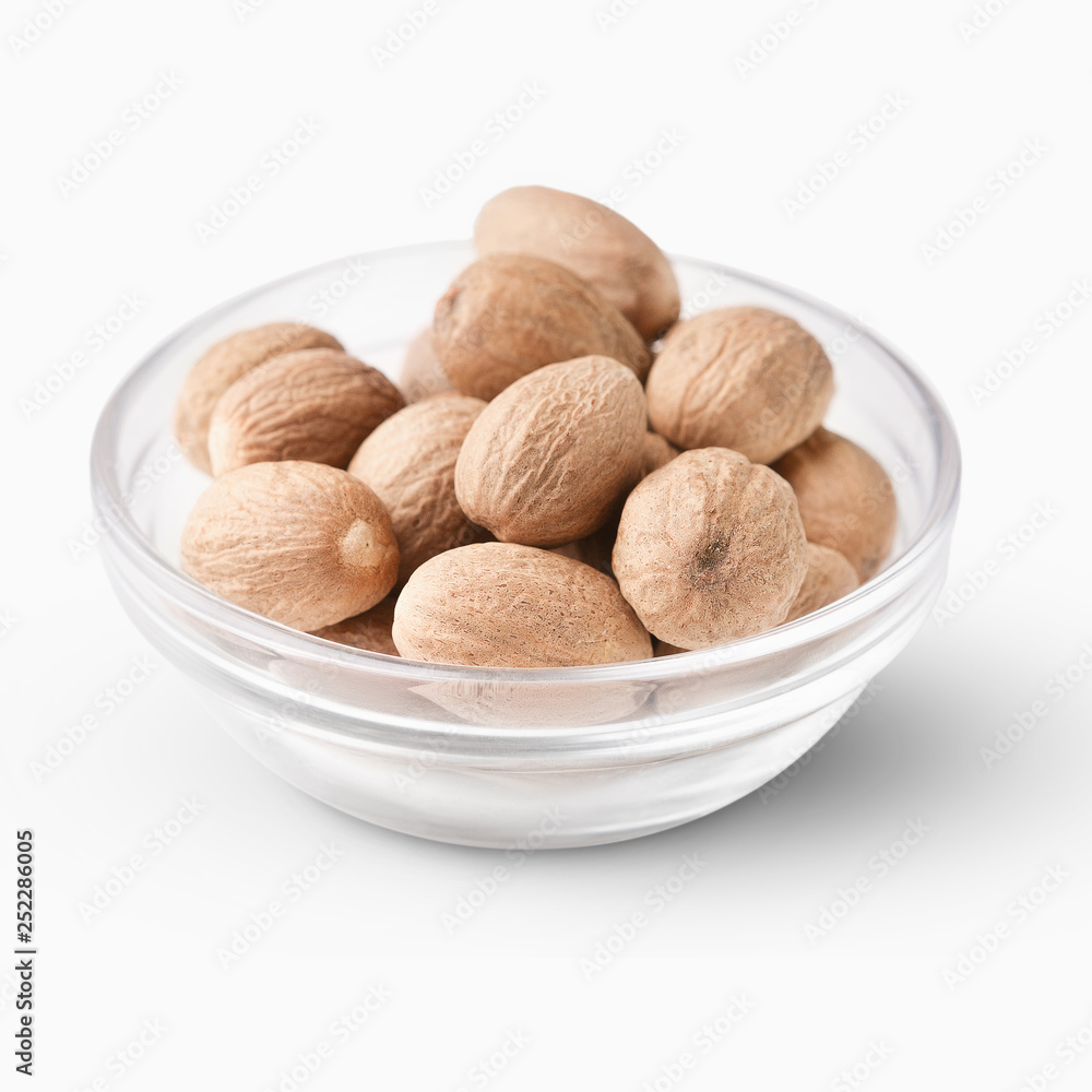 Nutmegs in glass bowl isolated on white background. Nutmegs in glass bowl isolated on white background.