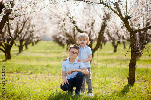 happy children on the street in the spring , flowering gardens