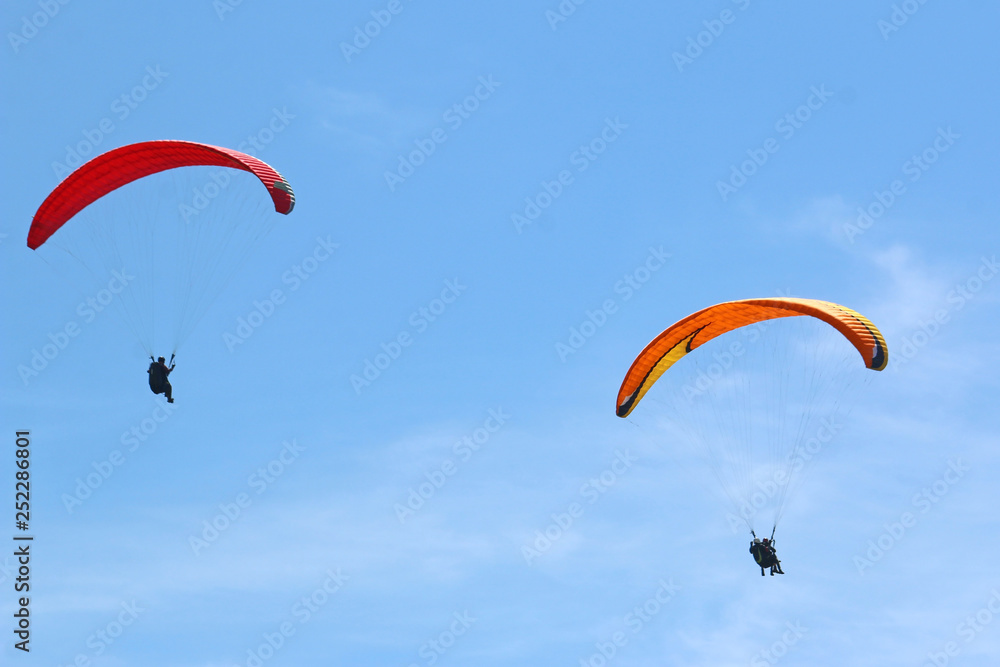 Paragliders flying in a blue sky Paragliders flying in a blue sky