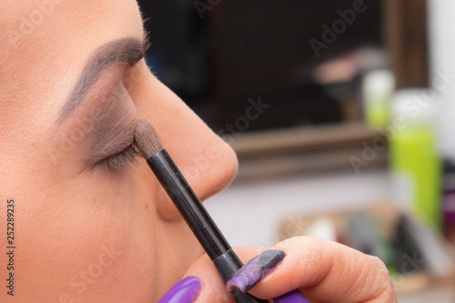 make-up artist applies make-up to a girl