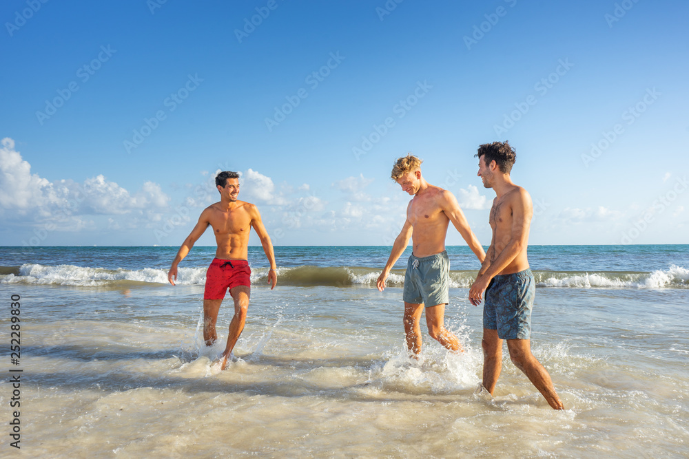 Group of young men playing at the beach