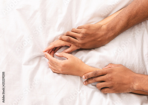 Man and woman hands having sex on bed