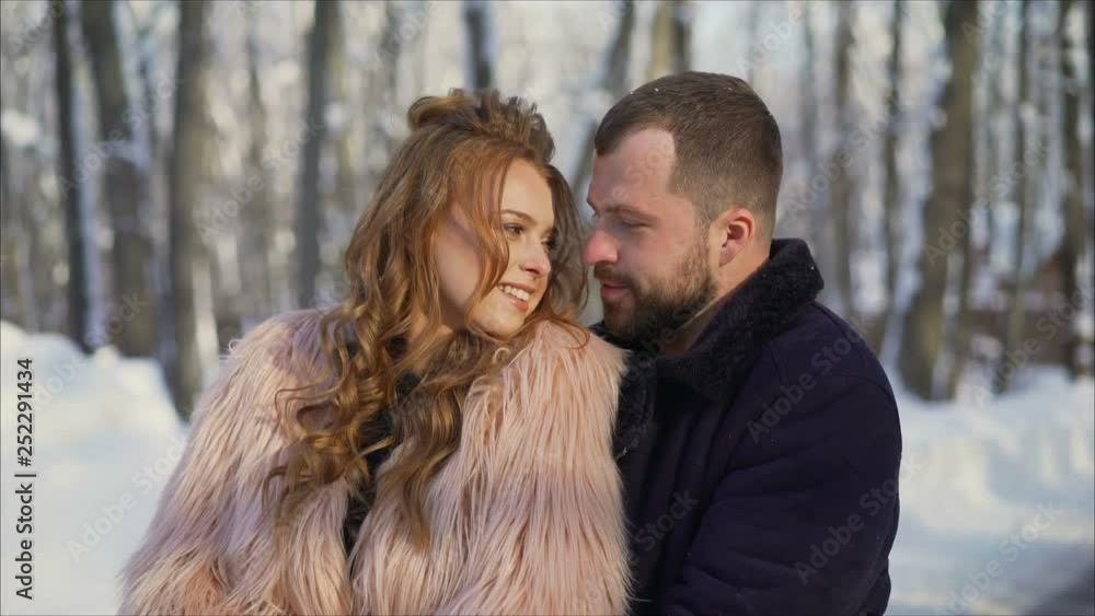 Girl and boy bask in the winter in the park. The guy and the girl are resting in the winter forest. Young couple walking in a winter park. Girl and boy bask in the winter in the park. The guy and the girl are resting in the winter forest. Young couple walking in a winter park.
