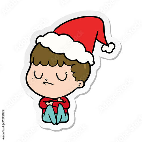 sticker cartoon of a grumpy boy wearing santa hat