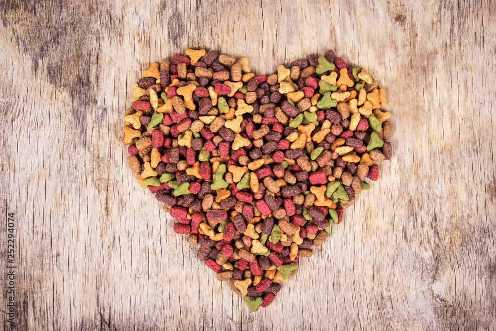 Cat food on wooden background. Cat food in the shape of heart. Top view. Cat food on wooden background. Cat food in the shape of heart. Top view.