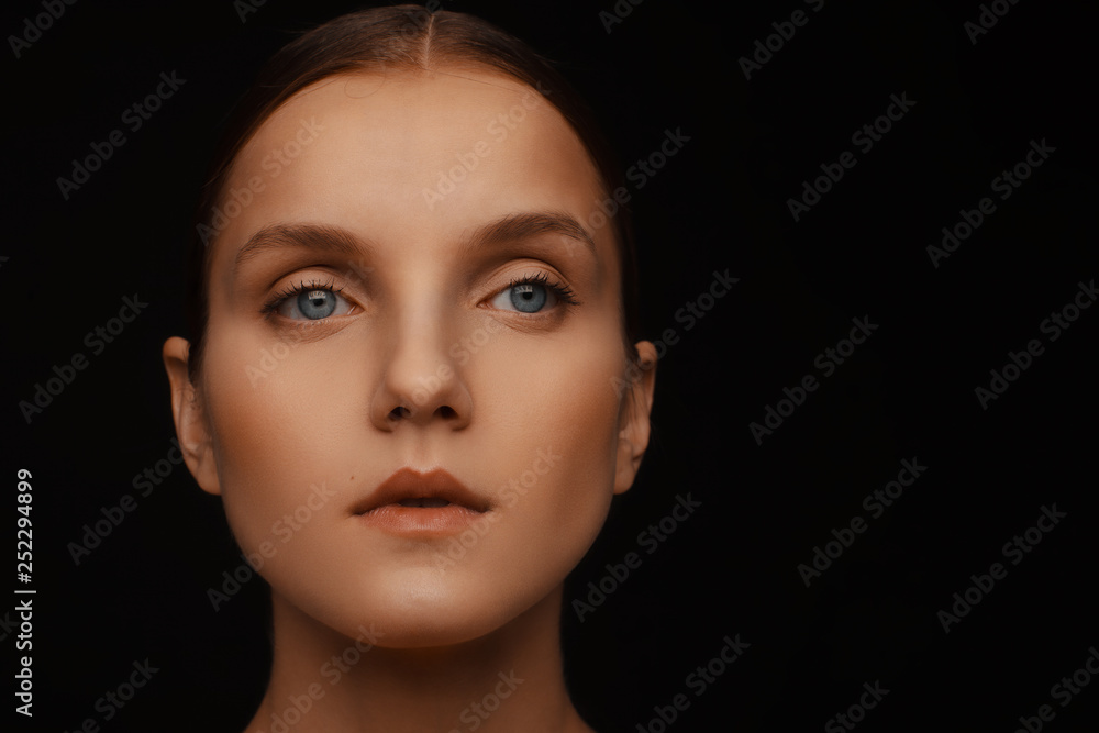 Close-up portrait of a beautiful model with clean makeup and collected hair, photographed in a photo studio Close-up portrait of a beautiful model with clean makeup and collected hair, photographed in a photo studio