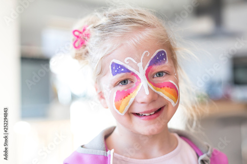 Fotografie Portrait of blonde girl smiling with painted face