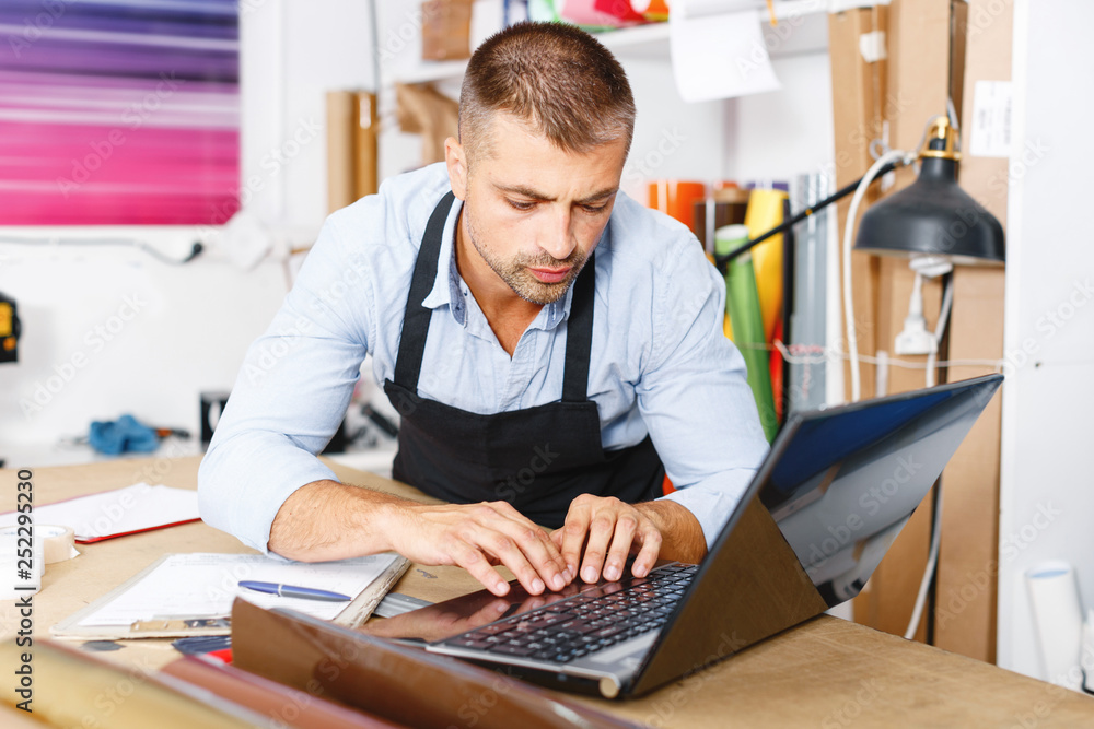 Fototapeta premium portrait of working advertising agency behind a laptop